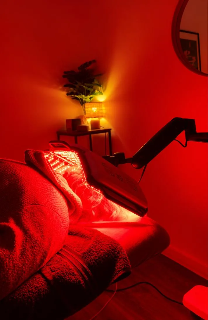 Cliente allongée en cabine sous le panneau EVA LED allumé en lumière rouge